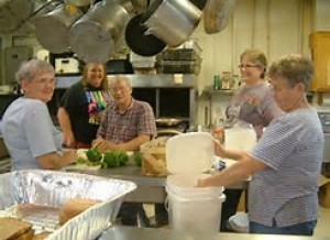 Volunteers assisting in kitchen for homeless