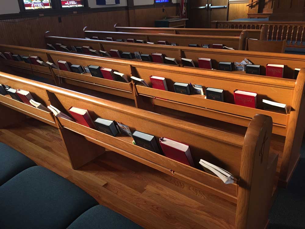 Church pews with hymn books and bibles